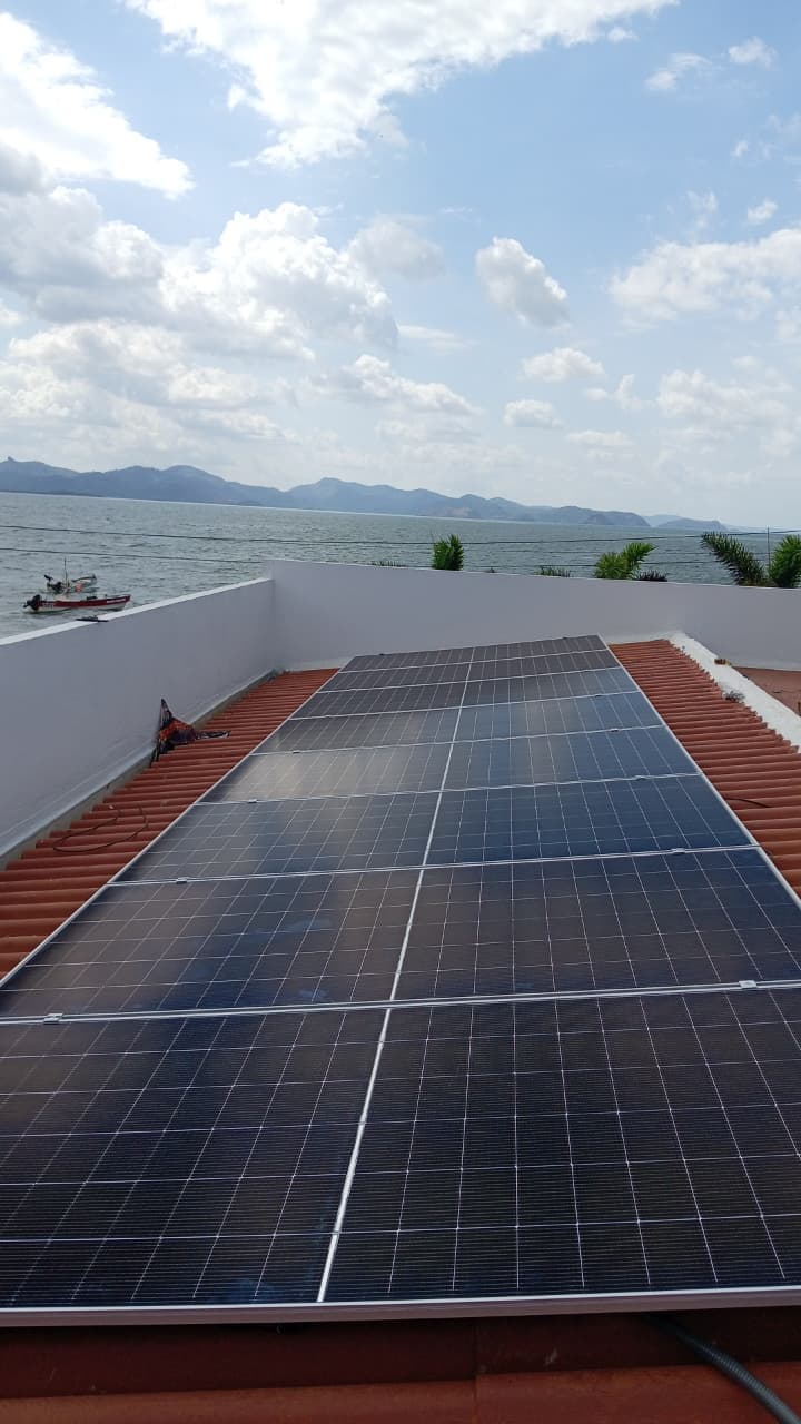 Finished rooftop solar array on a tile roof overlooking the bay in Punta Chame