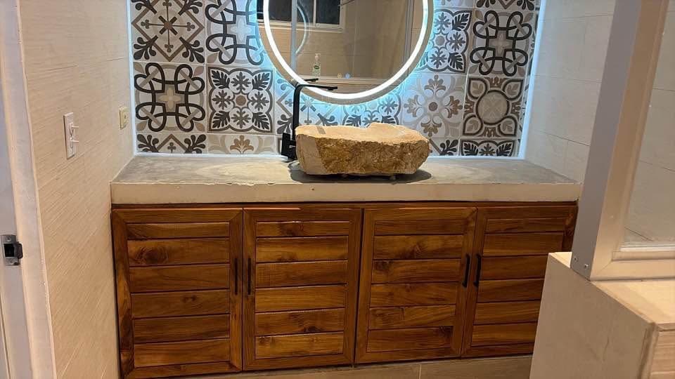 After: bathroom vanity fitted with custom wood cabinet doors beneath a stone vessel sink